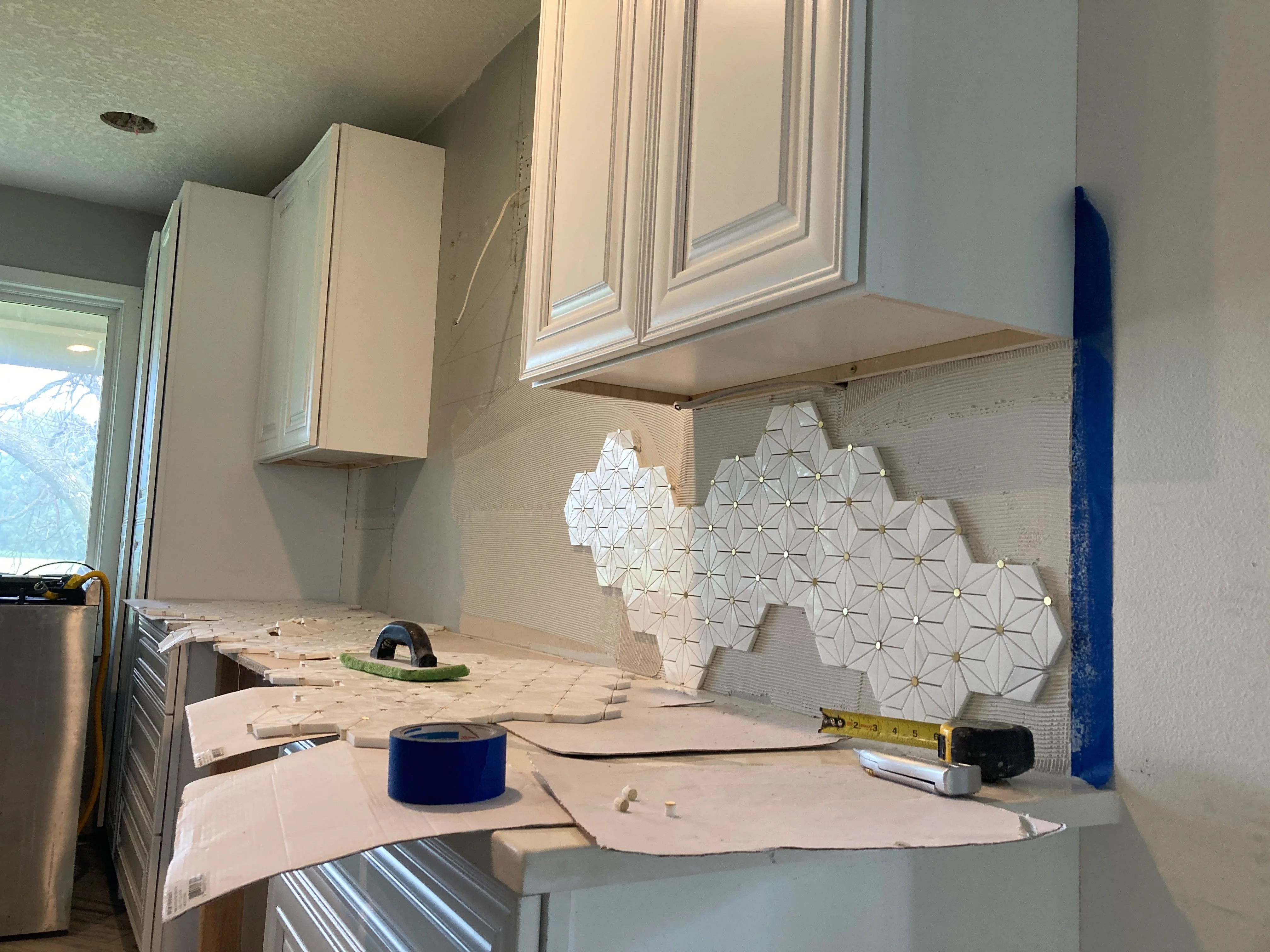 White hexagon mosaic kitchen backsplash tile installation
