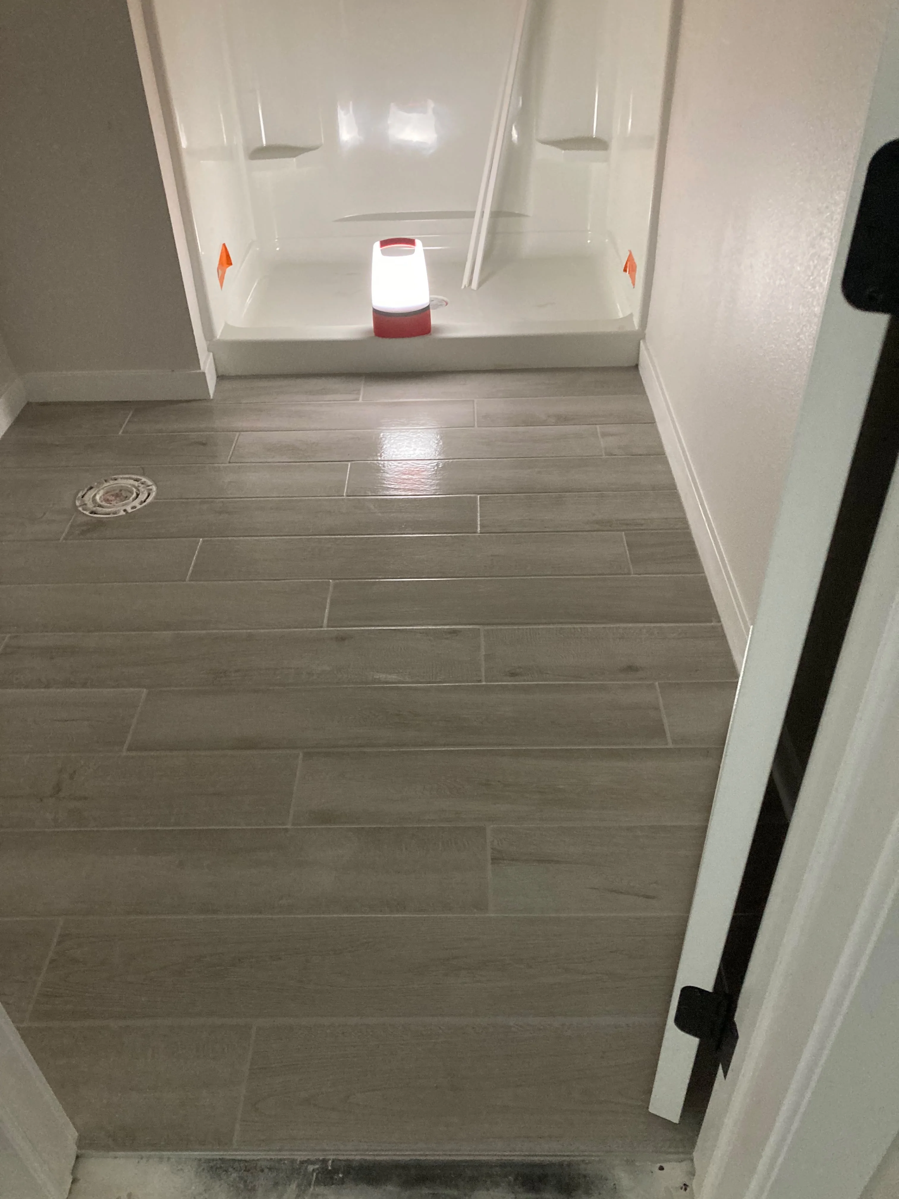 New shower stall installation with tile flooring